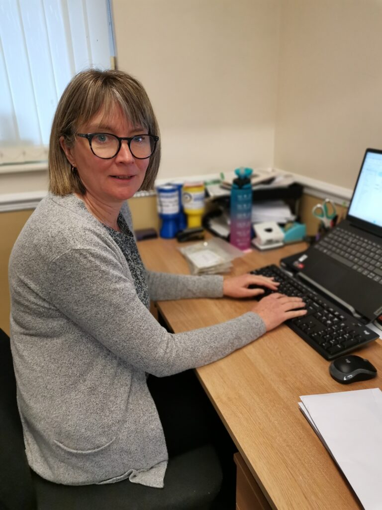 Gillian Coulson at her desk
